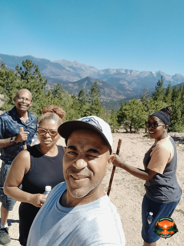 Group of hikers smiling on a sunny trail in the Rocky Mountains near Larimer County, Colorado